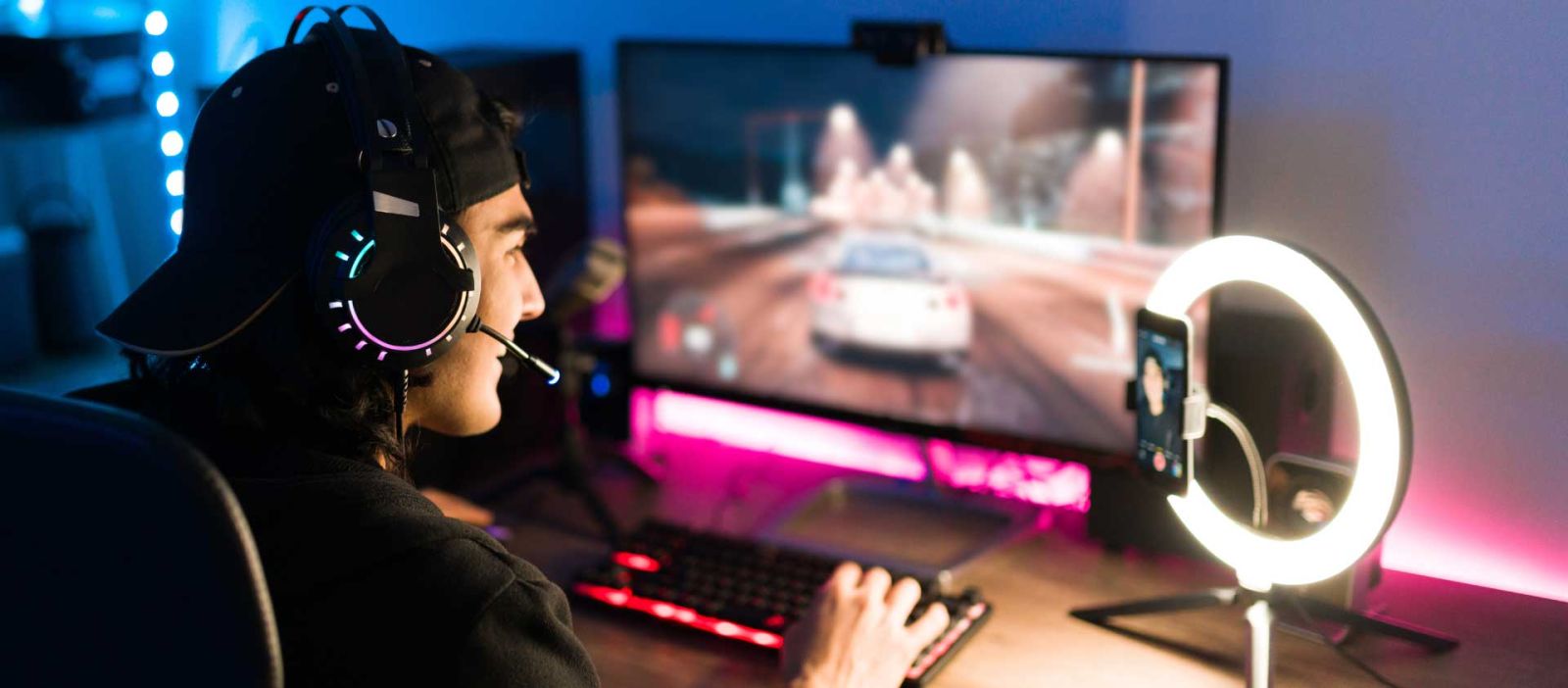 A male wearing a headset is playing a video game while entertaining his audience on a streaming platform.